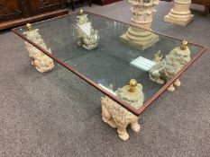 A contemporary glass coffee table foo dog supports with 154 cm x 93 cm