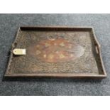 A carved Indonesian hardwood tray with brass inlay