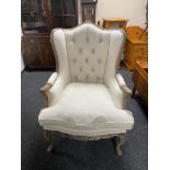 A wingback armchair in beige button fabric