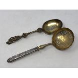 A 19th century silver strainer and a mid-Victorian silver gilt spoon dated 1856 (2)