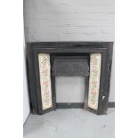 An antique cast iron tiled fire insert