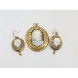A pair of yellow gold cameo earrings with matching pendant.