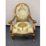 A large traditional style gilded armchair,