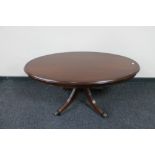 An oval inlaid mahogany pedestal coffee table together with matching nest of three tables