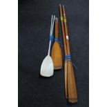 Two pairs of wooden oars and a pair of metal oars