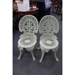 A set of four cast metal painted patio chairs