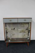 A mid century sliding glass door display cabinet together with a mid century blanket box