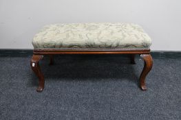 An antique mahogany duet foot stool on paw feet