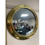 A brass mounted convex porthole mirror