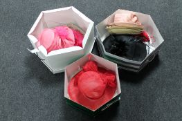 Three hat boxes containing formal hats and fascinators