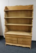 A set of blonde oak open shelves fitted five drawers beneath