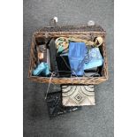 A wicker basket containing a collection of lady's handbags