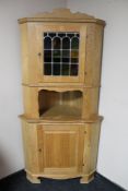A blonde oak corner cabinet