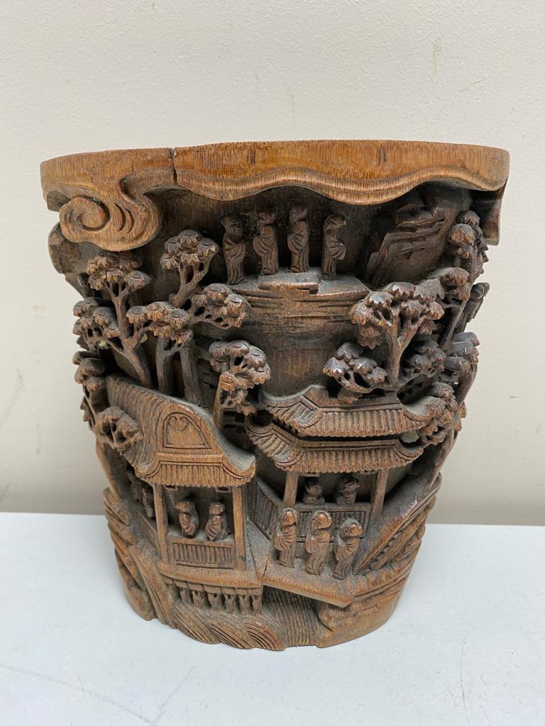 A late 19th century Chinese carved bamboo brush pot, intricately carved with figures and foliage,