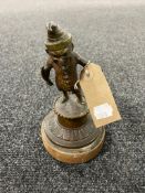 An antique bronze figure of a leprechaun on wooden base,