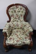A Victorian mahogany framed armchair in floral fabric