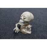 A cast iron novelty skeleton money box