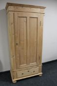 An antique pine hall wardrobe fitted a drawer