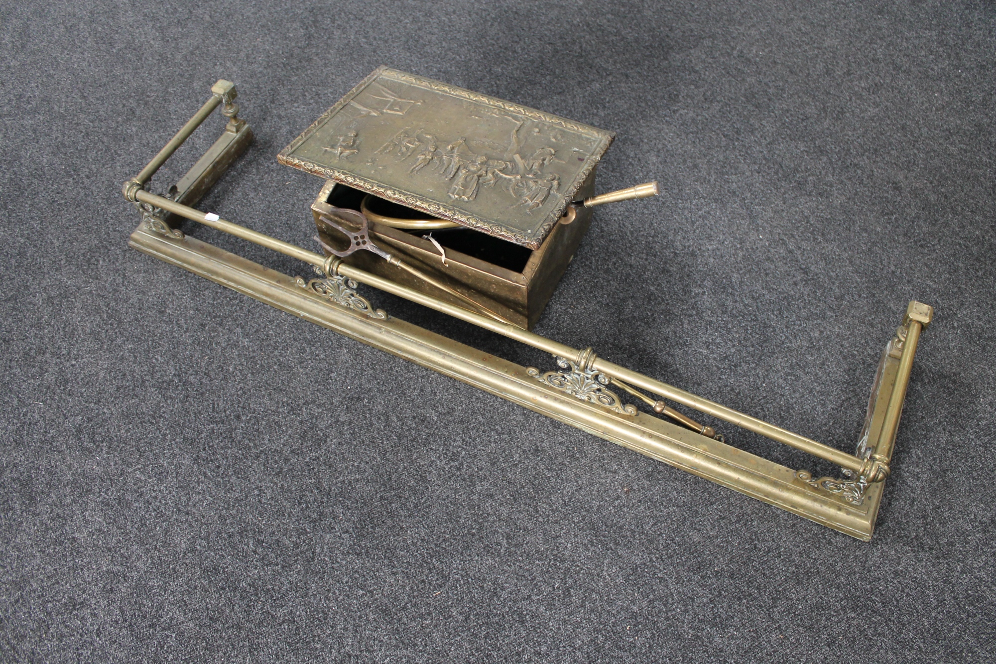 A Victorian brass fire curb, brass embossed slipper box containing fire poker,