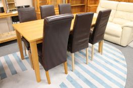 A contemporary oak dining table together with a set of five high back brown leather dining chairs