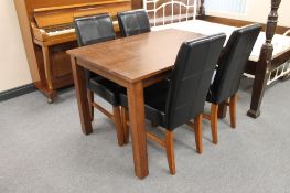 A contemporary stained pine kitchen table and four brown leather dining chairs