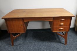 A mid 20th century teak twin pedestal writing desk