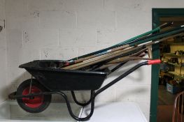 A wheelbarrow containing a quantity of garden tools