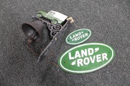 A cast iron Land Rover bracket with bell together with two Land Rover plaques