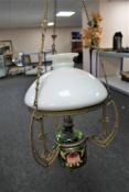 An antique brass and china hanging oil lamp with green glass reservoir,