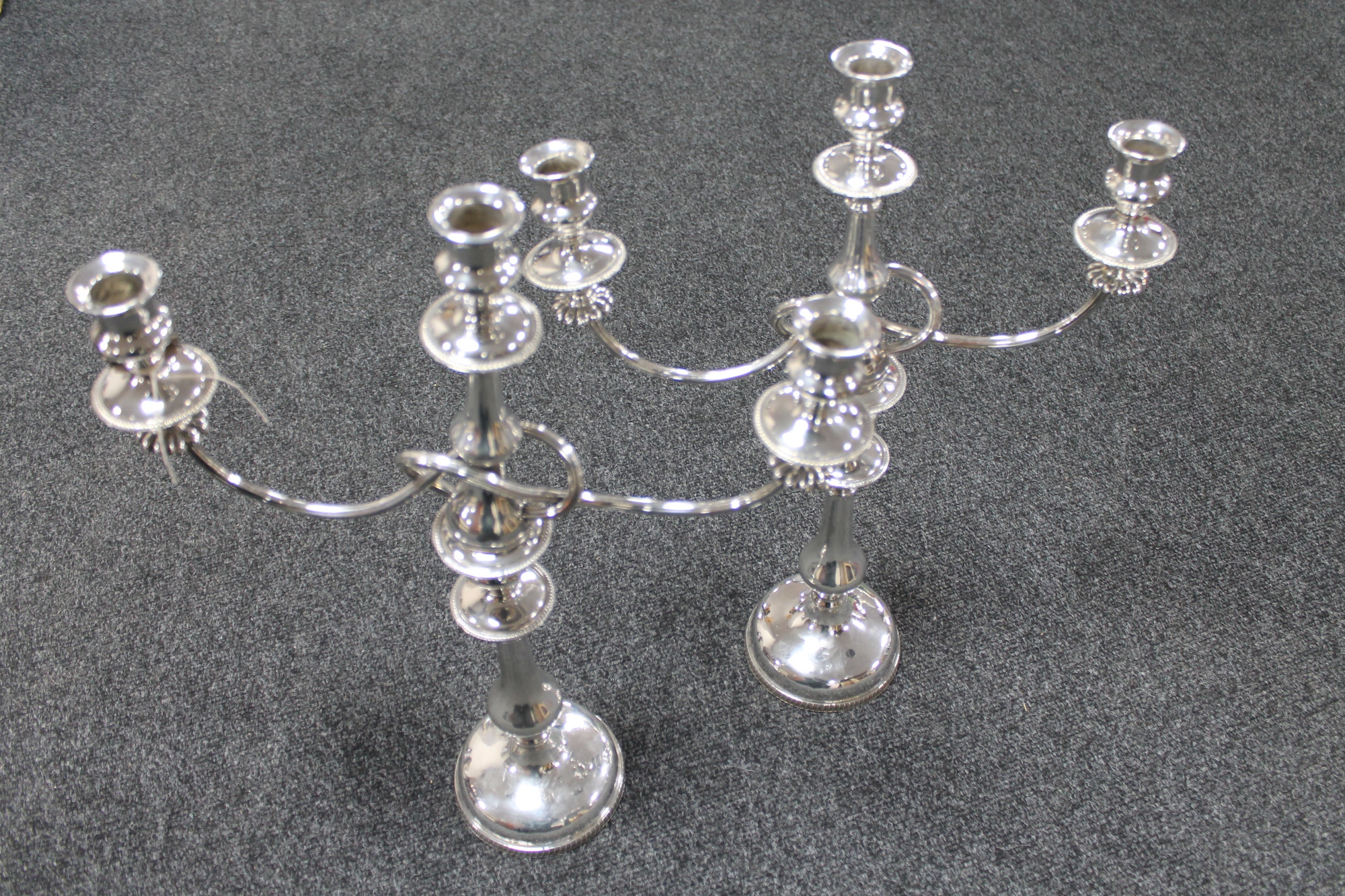 A pair of early 20th century silver plated three way table candelabra