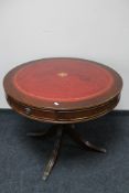 A mahogany pedestal drum table with red leather inset panel