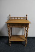 An early 20th century oak side table with gallery back