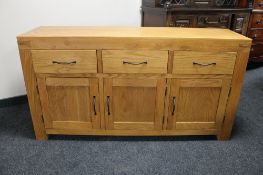 An oak triple door sideboard fitted three drawers