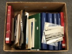 A box of stamp albums and postcards