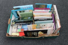 A box of books and folded maps of local interest