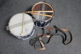 Two snare drums with drum sticks and three leather carrying straps