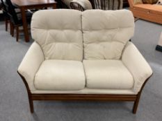 A late 20th century wood framed two seater settee in beige fabric