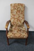 A teak framed high back armchair, a contemporary footstool upholstered in a cream fabric,