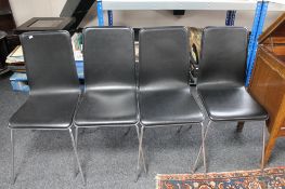 Four contemporary black leather dining room chairs on metal legs