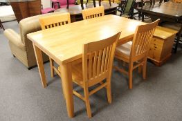 A pine kitchen table and four rail back chairs