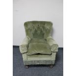 An early 20th century armchair in green button dralon