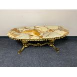 An oval onyx coffee table on ornate brass twin pedestal base CONDITION REPORT: