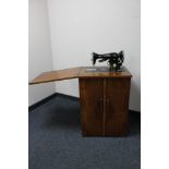 A Singer treadle sewing machine in walnut table with accessories