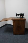 A Singer treadle sewing machine in walnut table with accessories