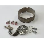 A silver bangle, Celtic brooch and five pairs of silver earrings.