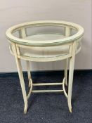 A reproduction cream curio table,