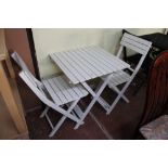 A folding wooden garden table with two chairs