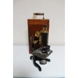 A black metal and brass Watson microscope in fitted mahogany box together with assorted accessories