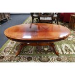 A Regency style oval coffee table on two way pedestal CONDITION REPORT: Faded top,