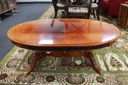 A Regency style oval coffee table on two way pedestal CONDITION REPORT: Faded top,
